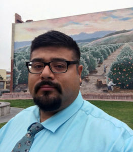Daniel Poo stands in front of a mural
