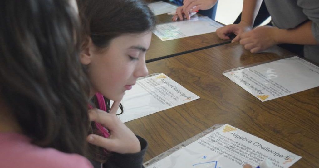 Middle school girls work on math problems together