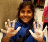 smiling student with sticky hands from science experiment